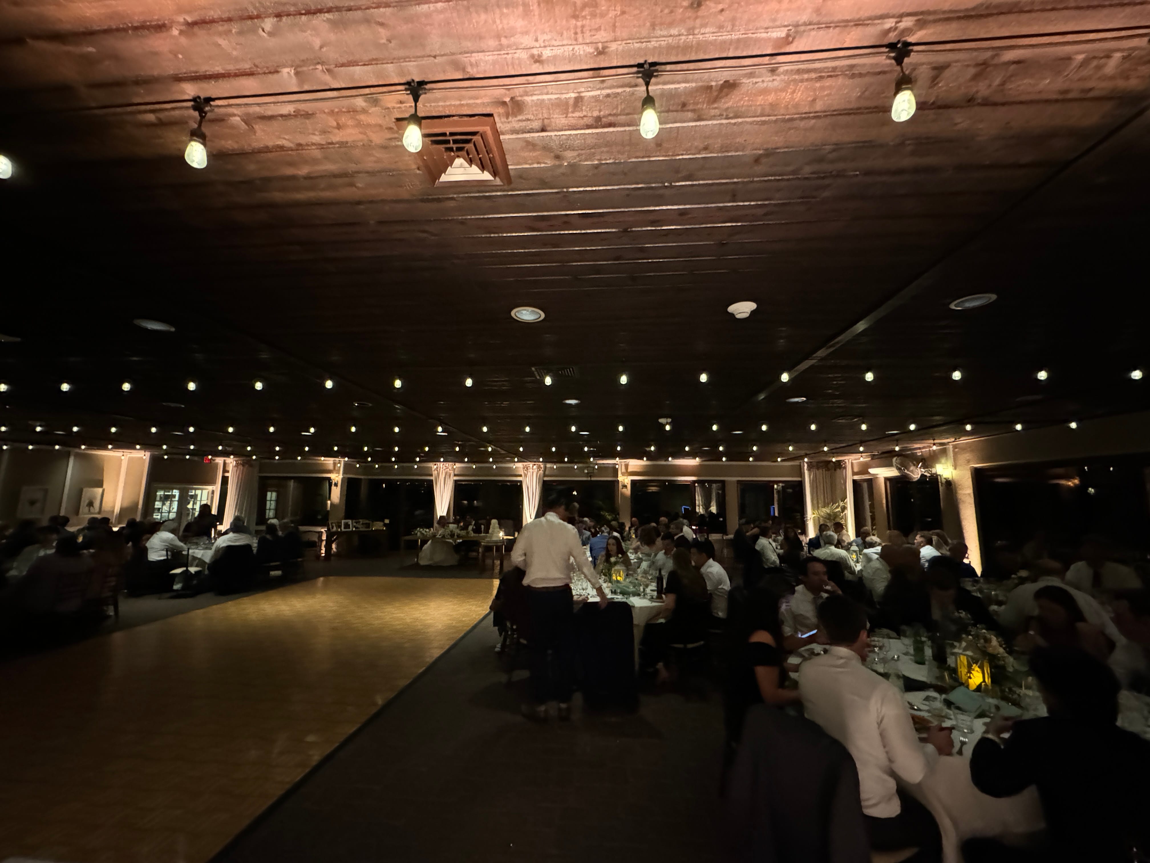 Long farm tables under bistro lighting at Ballyowen