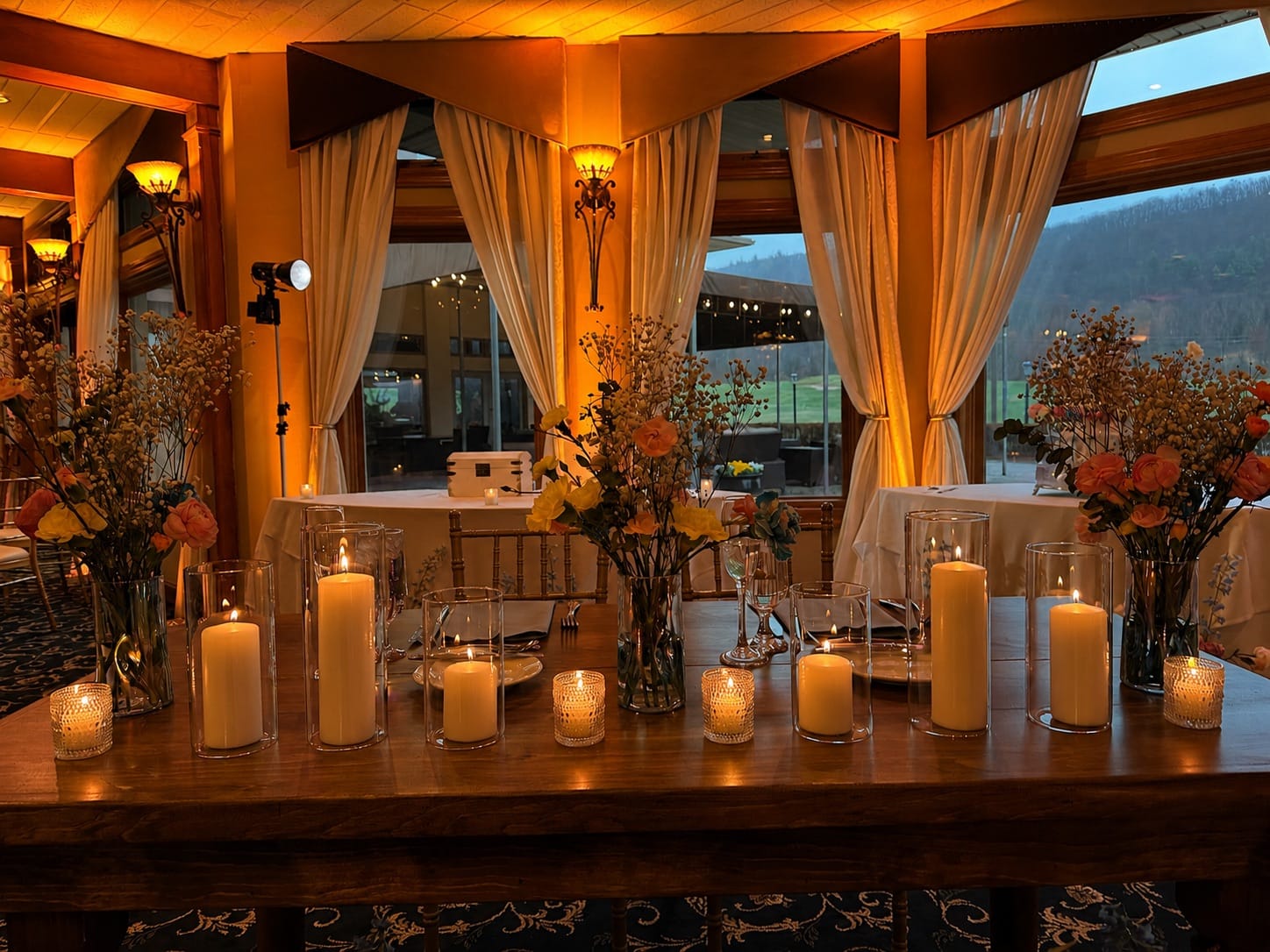 Sweetheart table glowing with warm amber uplighting and mountain views at Black Bear Golf Club, Crystal Springs Resort