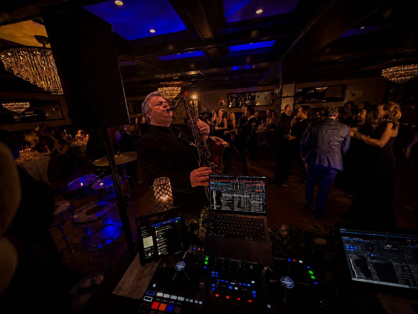 Doug on saxophone performing live at the DJ booth at Hotel du Village with a full dance floor