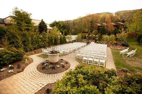 Outdoor wedding ceremony at Minerals Hotel & Spa with garden chairs, cobblestone circle, and mountain woodland backdrop
