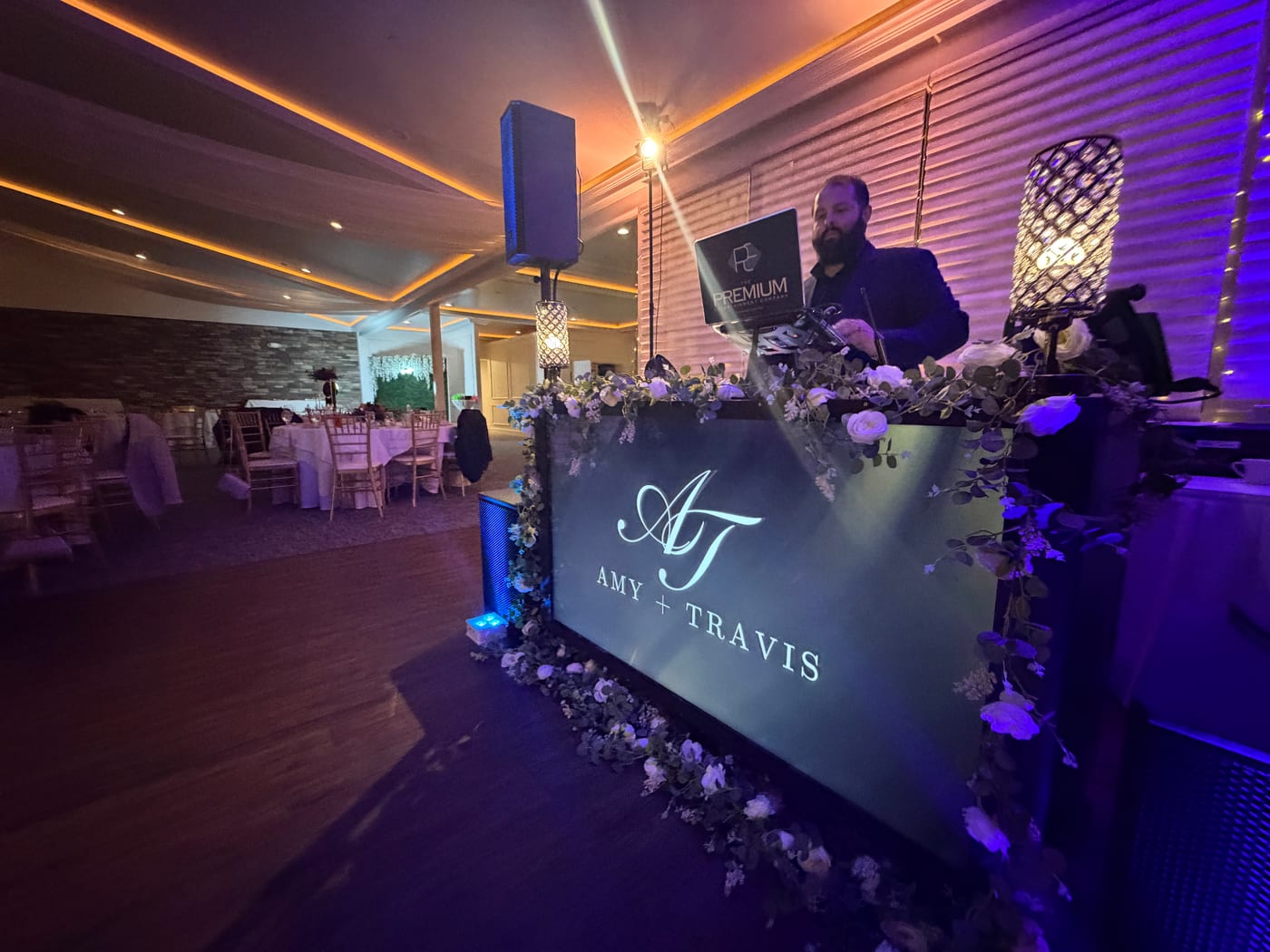 Custom monogram DJ booth with florals at a WoodStone Country Club wedding reception