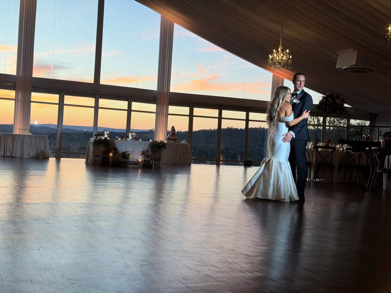 Newlyweds dancing beside the windows at sunset at Grand Cascades Lodge