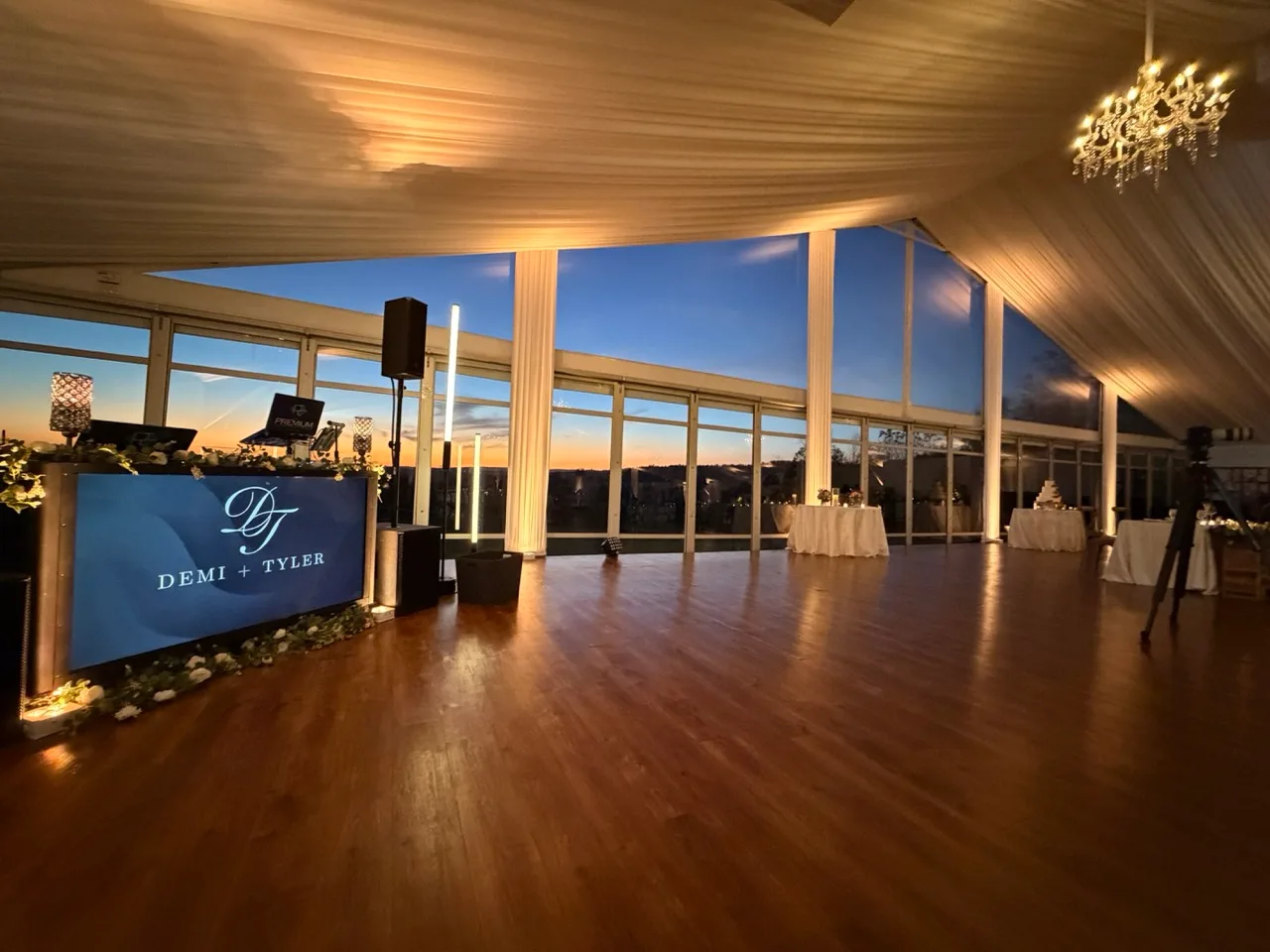 Personalized DJ display and dance floor beside sunset-lit windows at Grand Cascades Lodge