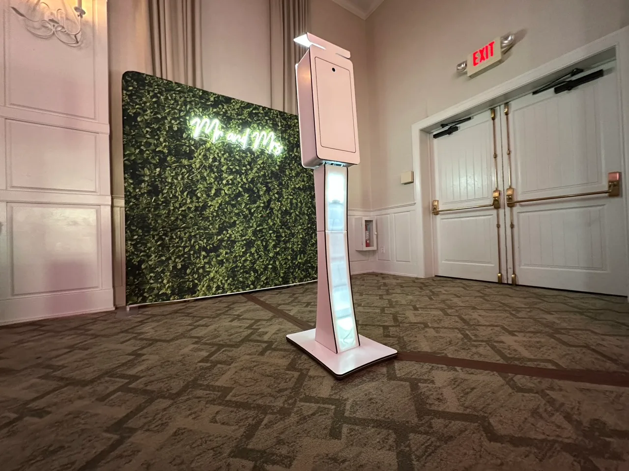 White open-air photo booth with a greenery backdrop at a Grand Cascades wedding
