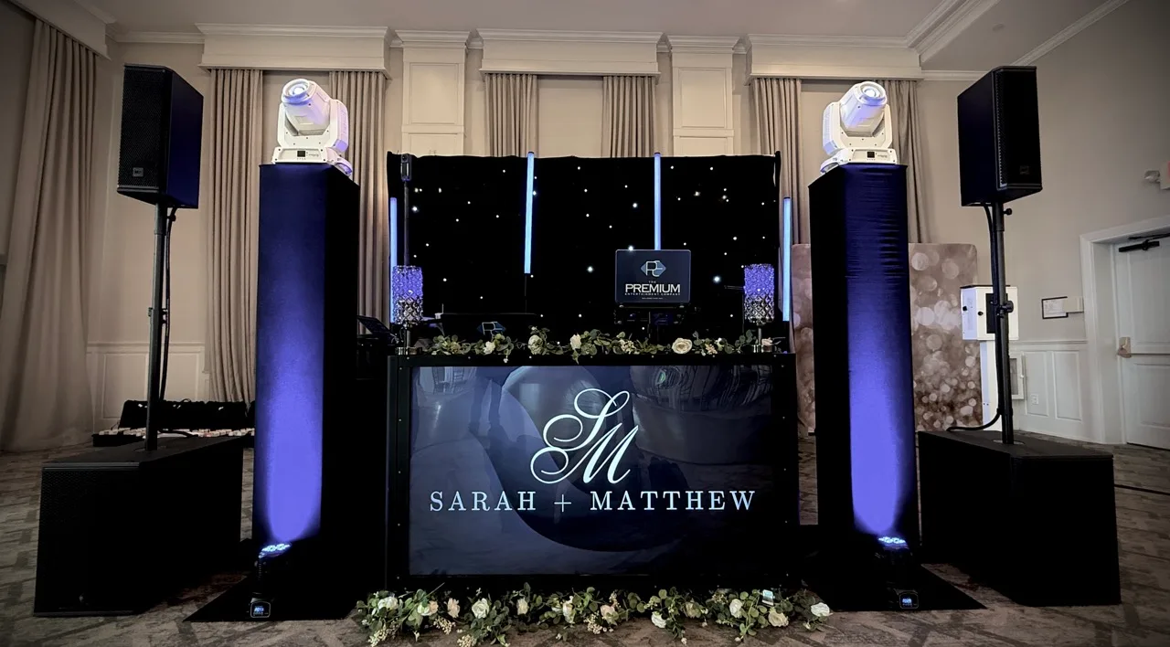 DJ booth with a personalized display, moving-head lights and purple-lit columns at Grand Cascades Lodge