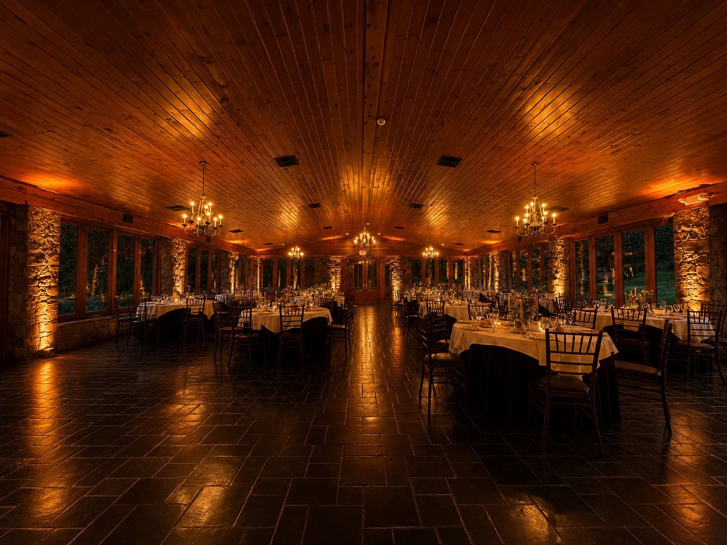 Lawnhaven at Stroudsmoor by Wedgewood Weddings with Premium Entertainment amber uplighting glowing across the stone columns and pitched wood ceiling at dusk
