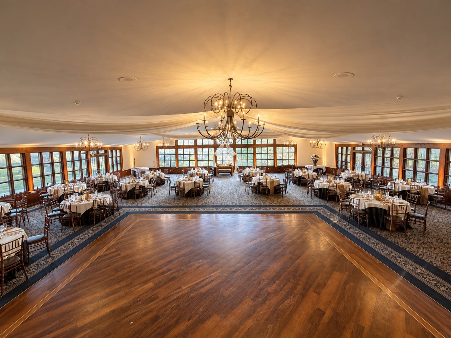 Ridgecrest at Stroudsmoor by Wedgewood Weddings — ballroom with chandeliers and draped fabric ceiling before uplighting